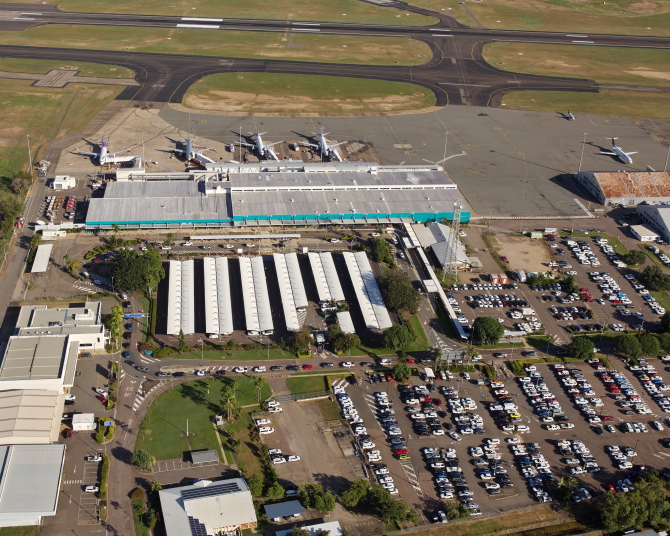 Aerial view of Townsville Airport showing terminal, parked aircraft, runways, and surrounding parking areas.