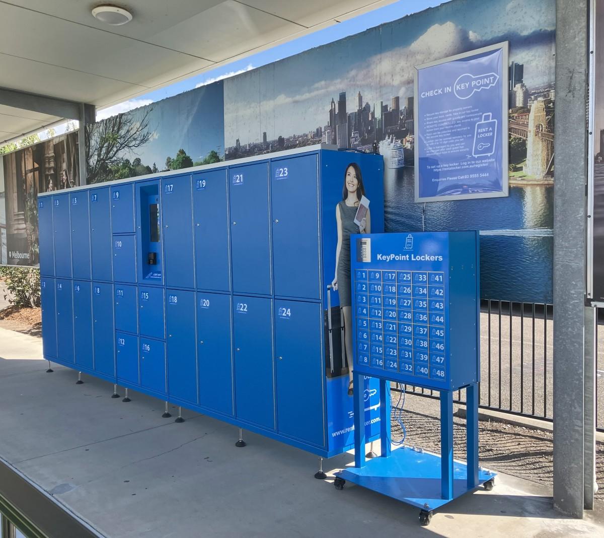 Outdoor RentALocker check-in area with blue KeyPoint Lockers, mural backdrop, and instructional signage.